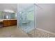 Modern bathroom with a glass shower, marble walls, neutral paint, and a wooden vanity at 1368 Fall River Dr, Conyers, GA 30013