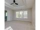 Bright bedroom with tray ceilings, neutral paint and large windows at 1368 Fall River Dr, Conyers, GA 30013