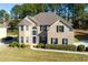 Charming two-story home with brick facade, landscaped yard, and mature trees at 1368 Fall River Dr, Conyers, GA 30013