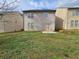 View of the home's backyard with a well-maintained lawn and a small patio, great for relaxing at 203 August West Way, Lawrenceville, GA 30046