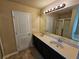 Bathroom with dual sinks, neutral walls, and vanity lighting at 203 August West Way, Lawrenceville, GA 30046