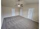 Bedroom featuring neutral walls, ceiling fan, carpeting and multiple door access points at 203 August West Way, Lawrenceville, GA 30046