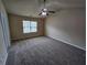 Spacious bedroom with neutral carpeting, ceiling fan and natural light from large window at 203 August West Way, Lawrenceville, GA 30046