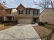 Two-story home featuring a front-entry garage and a long driveway leading up to the entrance of the house at 203 August West Way, Lawrenceville, GA 30046