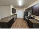 Kitchen featuring granite countertops, dark wood cabinets, stainless steel appliances and wood floors at 203 August West Way, Lawrenceville, GA 30046