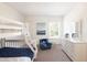 Cozy bedroom with a bunk bed, blue accent chair, and a dresser providing ample storage space at 45 Champions Blvd, Dallas, GA 30157