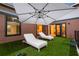Backyard featuring artificial turf, sun loungers, and a large patio umbrella, perfect for relaxation at 1045 Shepherds Ne Ln, Atlanta, GA 30324