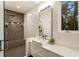Bright bathroom with a modern vanity, large mirror, and a glass-enclosed shower with built-in niche at 1045 Shepherds Ne Ln, Atlanta, GA 30324