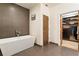 Sleek bathroom featuring a standalone tub with modern fixtures and a glimpse into the organized walk-in closet at 1045 Shepherds Ne Ln, Atlanta, GA 30324