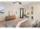 Sunlit bedroom with deck access features a ceiling fan, light wood floors, and neutral decor at 1045 Shepherds Ne Ln, Atlanta, GA 30324