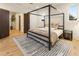 Sunlit bedroom with a modern four-poster bed, neutral decor, and light wood floors at 1045 Shepherds Ne Ln, Atlanta, GA 30324