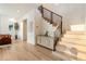 Inviting entryway featuring light wood floors, modern staircase with black railings, and stylish decor at 1045 Shepherds Ne Ln, Atlanta, GA 30324