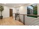 Open hallway with modern railing, light wood floors, and a view to the outdoors at 1045 Shepherds Ne Ln, Atlanta, GA 30324