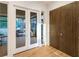 Hallway with white trim, wood floor, and glass French doors to the outdoor patio at 1045 Shepherds Ne Ln, Atlanta, GA 30324
