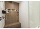 Close up of tiled shower, featuring a rainfall showerhead, built-in seating, and recessed shelving at 1045 Shepherds Ne Ln, Atlanta, GA 30324