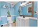 Light blue bathroom with a white vanity and decorative wooden mirror at 6510 Akins Way, Cumming, GA 30041