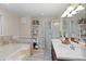 Bathroom with tub, glass shower, large mirror, double sinks, and a storage tower at 6510 Akins Way, Cumming, GA 30041