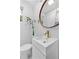 Modern bathroom featuring white tiles, a floating vanity, round mirror, and a bamboo plant adding a touch of nature at 1824 Windemere Ne Dr, Atlanta, GA 30324