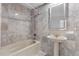 Elegant bathroom features beautiful marble tiling and a pedestal sink with a bathtub at 1824 Windemere Ne Dr, Atlanta, GA 30324