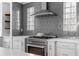 Close-up of a modern kitchen with stainless steel range and hood, gray tile backsplash, and white cabinets at 1824 Windemere Ne Dr, Atlanta, GA 30324