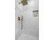 Luxurious shower with modern fixtures, white textured tile, and a built-in niche for toiletries at 1824 Windemere Ne Dr, Atlanta, GA 30324