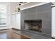 Modern fireplace with gray tile surround, flanked by white built-in cabinets, and hardwood floors at 2119 Dee Dee Muse Nw Ln, Atlanta, GA 30318