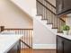 Elegant staircase design with iron railings and a view from the kitchen featuring marble countertops at 2119 Dee Dee Muse Nw Ln, Atlanta, GA 30318