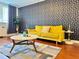 Stylish living room featuring a yellow sofa, hardwood floors, and patterned wallpaper, creating a modern and inviting space at 215 Piedmont Ne Ave # 602, Atlanta, GA 30308