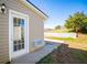 Image of back door surrounded by beige siding and greenery at 104 Providence Dr, Carrollton, GA 30116