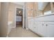 This bathroom has dual sinks, white cabinets, and tiled floors at 104 Providence Dr, Carrollton, GA 30116