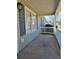 The front porch of a single-story home has a white railing and traditional light fixture at 325 Villa Rosa Way, Temple, GA 30179