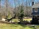 Picturesque backyard bordered by trees and lush landscaping with a partial view of the house at 92 Indian Lake Ct, Hiram, GA 30141