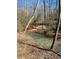 Backyard creek surrounded by large trees with creek bank covered in leaves and pine straw at 92 Indian Lake Ct, Hiram, GA 30141