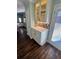 Hallway to kitchen with wooden floors, white cabinets, and glass shelving above counter at 92 Indian Lake Ct, Hiram, GA 30141