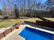 In-ground pool with surrounding modern fence, landscaping, and lounge chairs at 92 Indian Lake Ct, Hiram, GA 30141