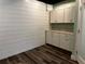 A room featuring white cabinets, faux-wood flooring, and shiplap style wall paneling at 92 Indian Lake Ct, Hiram, GA 30141