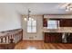 Kitchen featuring wood cabinets, granite counters, hardwood floor, and chandelier at 2685 Whippoorwill Cir, Duluth, GA 30097