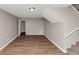 Basement with stairs and door, wood-look flooring, and freshly painted walls at 3671 Satellite Blvd, Ellenwood, GA 30294