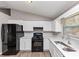 Bright kitchen featuring white cabinets, black appliances, and modern finishes at 3671 Satellite Blvd, Ellenwood, GA 30294