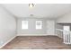 Bright living room with light wood flooring, two windows, and access to the staircase at 3671 Satellite Blvd, Ellenwood, GA 30294