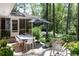 Outdoor patio area features a dining table, seating, an umbrella, and lush landscaping at 4323 E Durham Cir, Stone Mountain, GA 30083