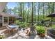 Lush backyard patio features outdoor dining and seating area shaded by trees and umbrellas at 4323 E Durham Cir, Stone Mountain, GA 30083