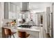 Bright, modern kitchen featuring white cabinetry, stainless steel appliances, and a marble backsplash at 4323 E Durham Cir, Stone Mountain, GA 30083