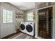 Well-appointed laundry room with modern washer and dryer, wine fridge, and unique wallpaper at 4323 E Durham Cir, Stone Mountain, GA 30083
