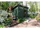 Outdoor shed featuring a covered porch, double doors, and surrounded by lush landscaping at 4323 E Durham Cir, Stone Mountain, GA 30083