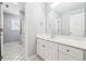 This bathroom features a large vanity, white cabinets, a mirror, and tile flooring at 385 Sweet Ivy Ln, Lawrenceville, GA 30043