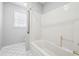 This bathroom has a shower-tub combo, tile walls, and modern fixtures at 385 Sweet Ivy Ln, Lawrenceville, GA 30043