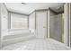 Bright bathroom features a soaking tub, glass shower, and classic patterned wallpaper at 385 Sweet Ivy Ln, Lawrenceville, GA 30043