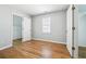 This cozy bedroom features wood floors, a closet, a window, and neutral paint at 385 Sweet Ivy Ln, Lawrenceville, GA 30043