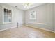 An empty room with tile floors, two windows, a chair rail, and a ceiling fan at 385 Sweet Ivy Ln, Lawrenceville, GA 30043